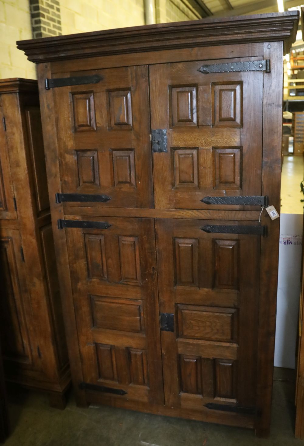 A French oak rustic-style panelled cupboard fitted upper and lower pairs of doors, width 122cm, depth 50cm, height 198cm